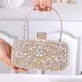 Detail of evening clutch bag featuring gold hollow lace and sparkling marquise crystals - White