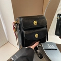 Black leather crossbody bag featuring double gold buckles and a decorative strap - Black