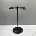 Rotating black metal jewelry stand for necklaces and earrings on marble surface - Black Round Base