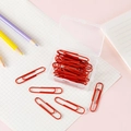 Standard red coated metal paperclips in a clear storage box for office stationery - Red