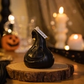 Detail of a black ghost pumpkin scented candle on a rustic wood slice for Halloween decor - Funny Ghost Pumpkin / Black