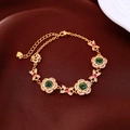 Dettaglio macro del bracciale floreale placcato oro 24K con pietre verdi su seta - Oro-Verde