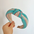 Detail of teal and beige pleated satin headband with a creative knot design - Knot Headband / Blue