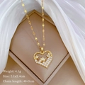 Goldene Herz-Halskette mit Stern-Inlay und Maßen 2.1x2.4cm auf beigem Hintergrund - Gold Herz & Stern Stil