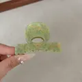 Detail view of 6cm green marble acetate hair claw clip with anti-slip spring teeth design - Green