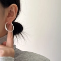 Nahaufnahme eines großen minimalistischen gebürsteten Silberohrrings am Modell - Gebürstetes Silber
