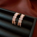 Detailed close-up of 18K gold-plated C-shaped earrings with pearls and zircon on dark leather - C-Shape Half Round Earrings / Gold with Pearl White