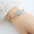 Dettaglio del bracciale infinito in oro rosa con occhio blu e zirconi bianchi - Oro rosa