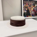 Detailed shot of white flat top straw hat featuring a wide pleated brown ribbon accent - White/Coffee Ribbon
