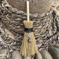 Detail shot of a mini wicca broom car charm with silver moon and star charms in nature - Moon & Star