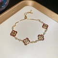 Detail of adjustable four-leaf clover bracelet with gold chain and red stones - Red