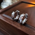 Dettaglio macro di orecchini d'argento che mostra la trama metallica martellata - Stile Increspato Placcato Oro / Argento