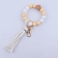 Detalle de llavero de pulsera de cuentas de silicona con borla blanca y cuenta de madera. - Blanco