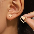Dettaglio di orecchini a cuore in oro con doppio design a incastro indossati sull'orecchio - Orecchini a Cuore in Acciaio Inossidabile (Oro KC 6304)