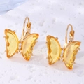Vista macro detallada de pendientes de mariposa de cristal con acabado dorado - Amarillo Dorado