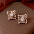 Dettaglio orecchini a fiore traforati in oro rosa con zirconi su scatola marrone - Oro Caffè Chiaro