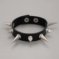 Detail eines schwarzen Leder-Punk-Armbands mit silbernen Metallspikes und Druckknöpfen - Schwarz