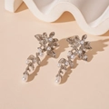 Detail of silver metallic flower earrings with white pearls on a minimalist background - Silver Flower Pearl Earrings