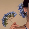 Detail of blue floral hairpin set with gold finish and rhinestone accents on model - Blue Hair Stick Earrings Set