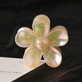 Pearlescent flower hair claw clip with translucent resin petals on dark fabric background - Iridescent Blue Purple