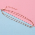 Detail van roségouden dubbellaagse kralenketting met karabijnsluiting en verlenging - Roségoud