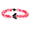 Macro detail of pink translucent beaded bracelet with a glittering blue butterfly bead - Peach Pink + Blue Sandstone Butterfly
