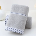 Absorbent grey cotton towel with blue checkered border on white vanity countertop - Cotton Houndstooth Grey (Towel)