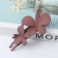 Elegant matte dusty pink double butterfly hair clip displayed on a book - Dusty Pink