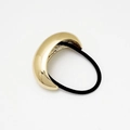 Macro shot of polished gold metal ponytail cuff hair ring with black elastic cord - Style A-Gold