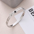 Brazalete de acero inoxidable 18K plateado con corazones de pavé en blanco y negro - Color Acero
