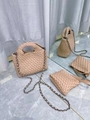 Beige woven bucket bag with metal chain strap and matching mini pouch on marble - Khaki