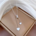 Macro-opname van zilveren hartketting met schelpinleg en pavé-stenen op zijde - Roestvrijstalen Ketting Koperen Micro-gezette Hart Hanger / Zilver