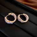 Dettaglio macro di orecchini a cerchio dorati con pavé di zirconi viola brillanti - Cerchio Dorato con Strass Viola