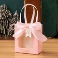 Pink gift bag with transparent window, large satin bow, and decorative hang tag - Pink + Women's Day Tag