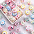 Colorful resin cake-shaped beads for DIY phone chains and accessories on a white plate - Mixed