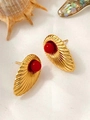 Macro detail of vintage gold shell earrings with red bead on white silk background - Red Bead Shell