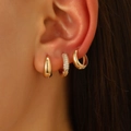 Dettaglio di orecchini a cerchio dorati minimalisti con pavé di zirconi bianchi - Orecchini Huggie in Zirconia Pavé Oro (A-62)