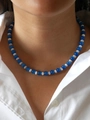 Detail of glacier blue cat eye beaded necklace with white spacers on a model collar - Shell Blue Cat's Eye 38+5cm