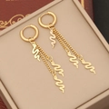 Vue macro des boucles d'oreilles serpent dorées avec chaînes à franges sur un coffret à bijoux - 1# Style de Pompon Serpent