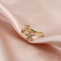 Detailed view of two gold floral rings with micro-set zircons on soft pink silk - T-Double Flower Open