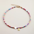 Close-up of colorful beaded necklace featuring a white heart and golden letter Z pendant - Letter Z