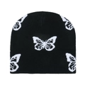 Detailed close-up of a black knit beanie featuring white butterfly jacquard patterns - Butterfly (F)