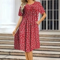 Detail of red floral print dress with round neck and short sleeves in outdoor setting - Red Floral