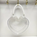 Detailansicht einer herzförmigen transparenten Tasche mit elegantem weißem Perlenkettengriff - Weiß