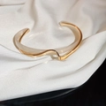 Dettaglio del bracciale aperto ondulato in oro e avorio su sfondo di seta bianca - Oro-Torto-Placcatura in Oro Reale (21#)