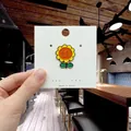 Cute sunflower enamel pin with yellow petals and green leaves on a display card - 125*Sun Flower Enamel Pin