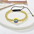 Pulsera de ojo turco hecha a mano con cuentas doradas y cordón ajustable sobre mármol - Estilo Ojo de Colores (221025-B-G-4)