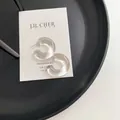 Minimalist transparent C-shaped resin hoop earrings with silver pins on a card - Clear