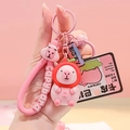 Pink Capybara keychain featuring a pink leather strap, bell, and a small red hat doll - Tomato Pink Capybara PVC