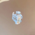 Detalle de anillo plateado textura lava con concha y perlas sobre fondo espejo - Estilo Cuadrado Azul de Plata